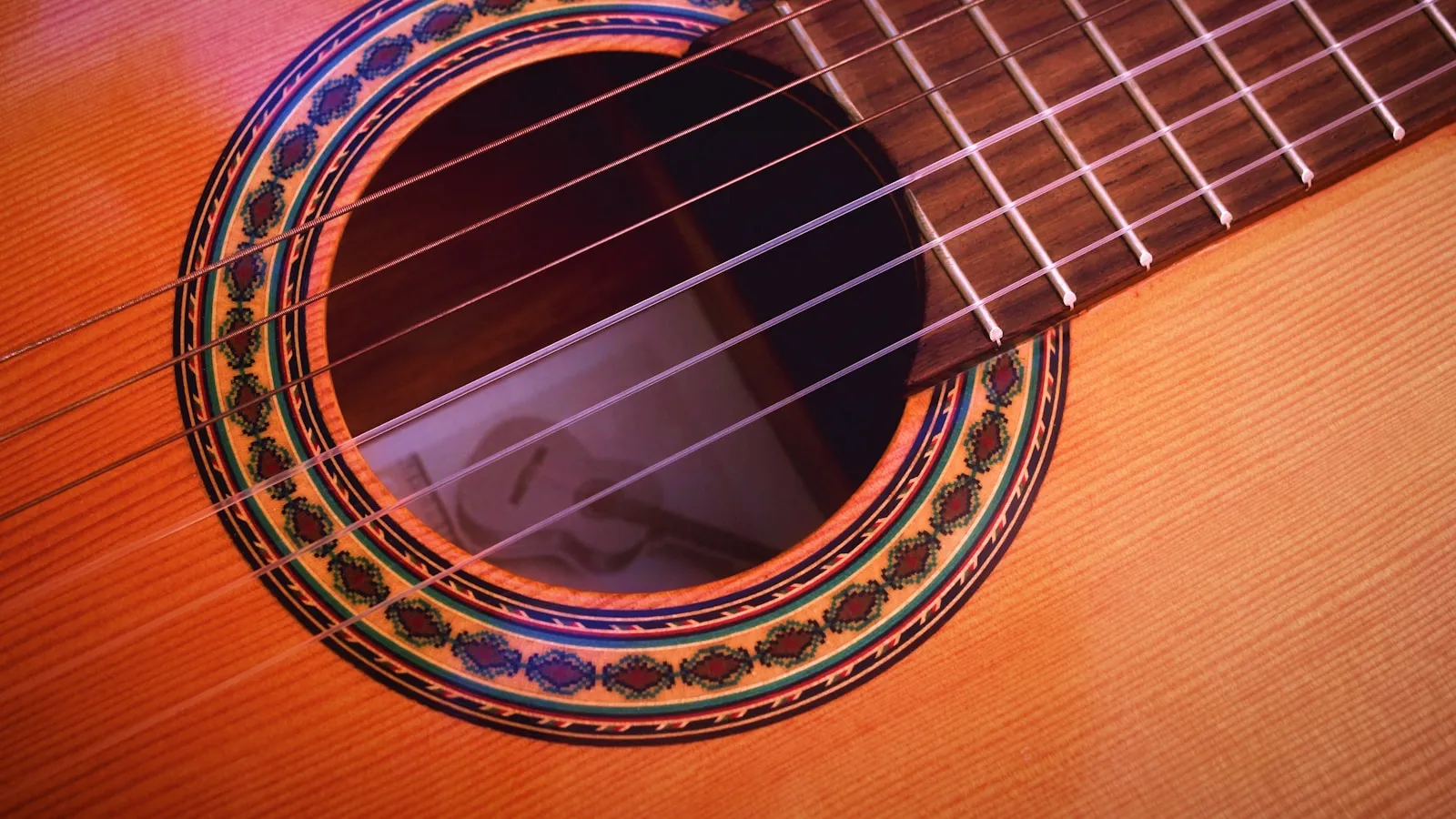 Close-up of an acoustic guitar's soundhole, rosette and spruce top